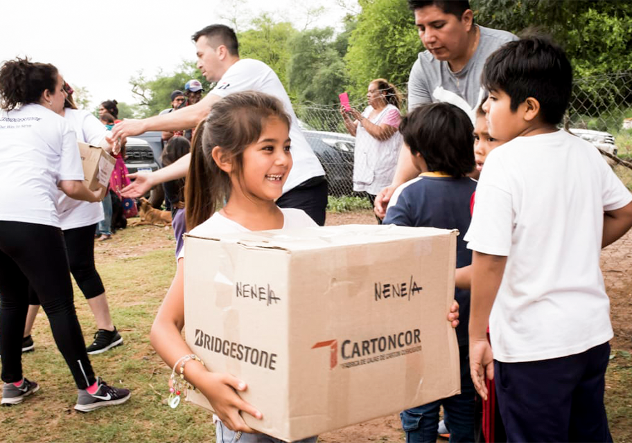 Niños cargando cajas de donaciones